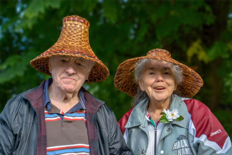 Elder Janet Moore with a man wearing traditional woven cedar hats