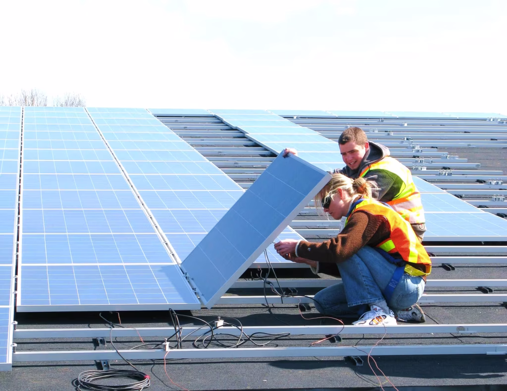 Michelle mentoring Frank at T'Souke First Nation installing photovoltaic cells