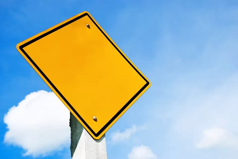 blank yellow warning sign with sky