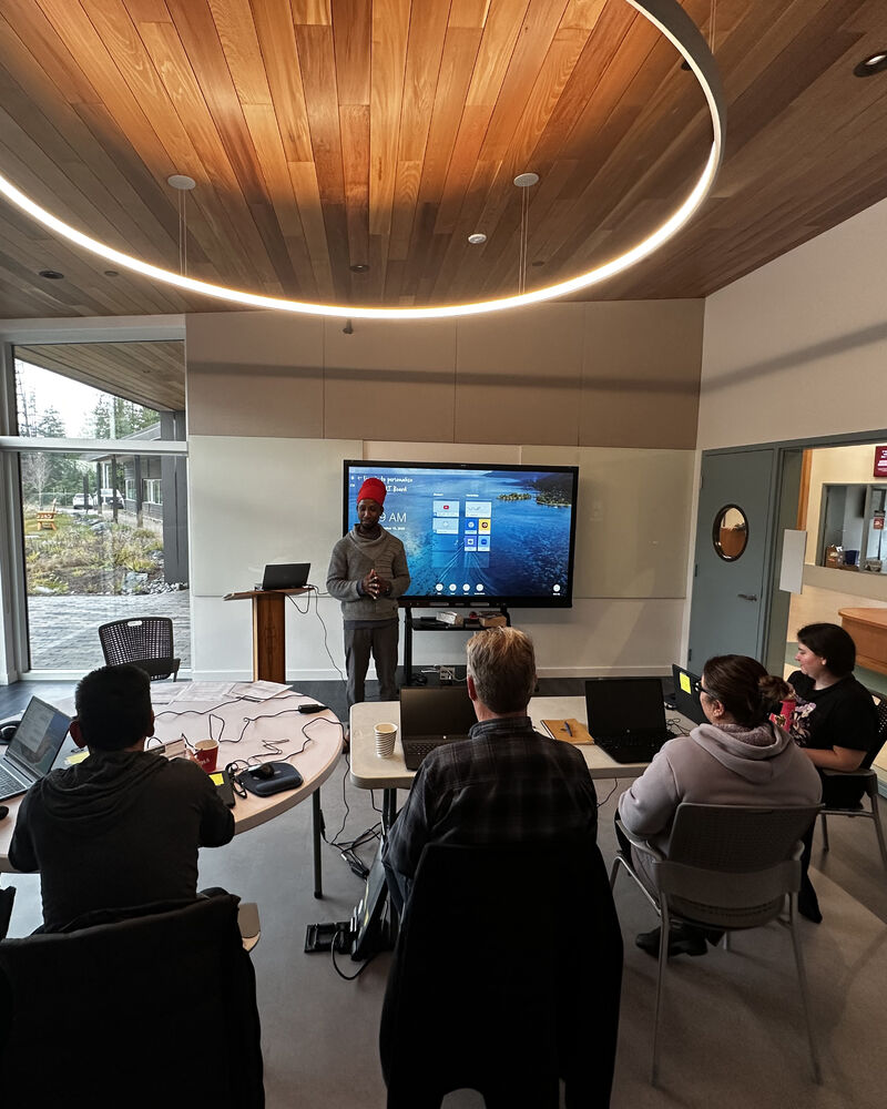 A man presents Microsoft training in small office classroom